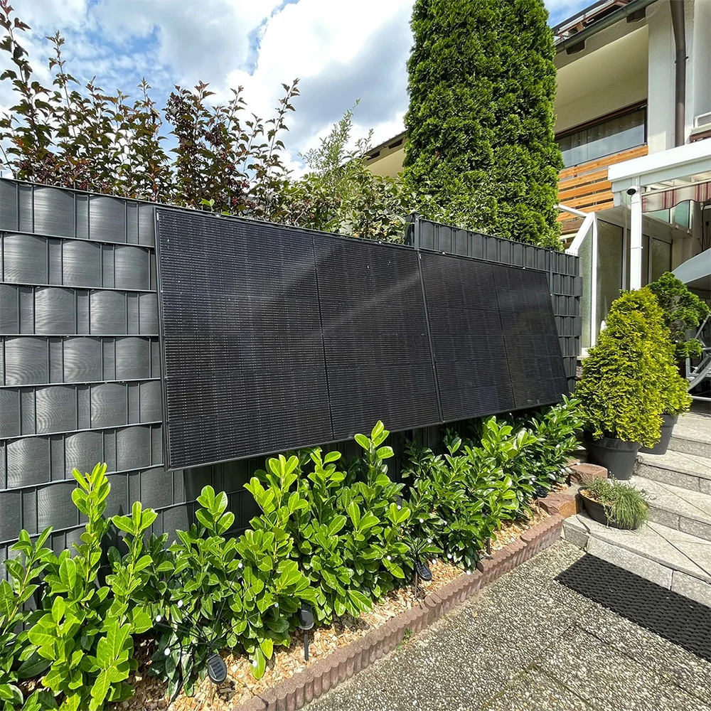 2 montierte PV Module an Zaun im Garten vor der Treppe